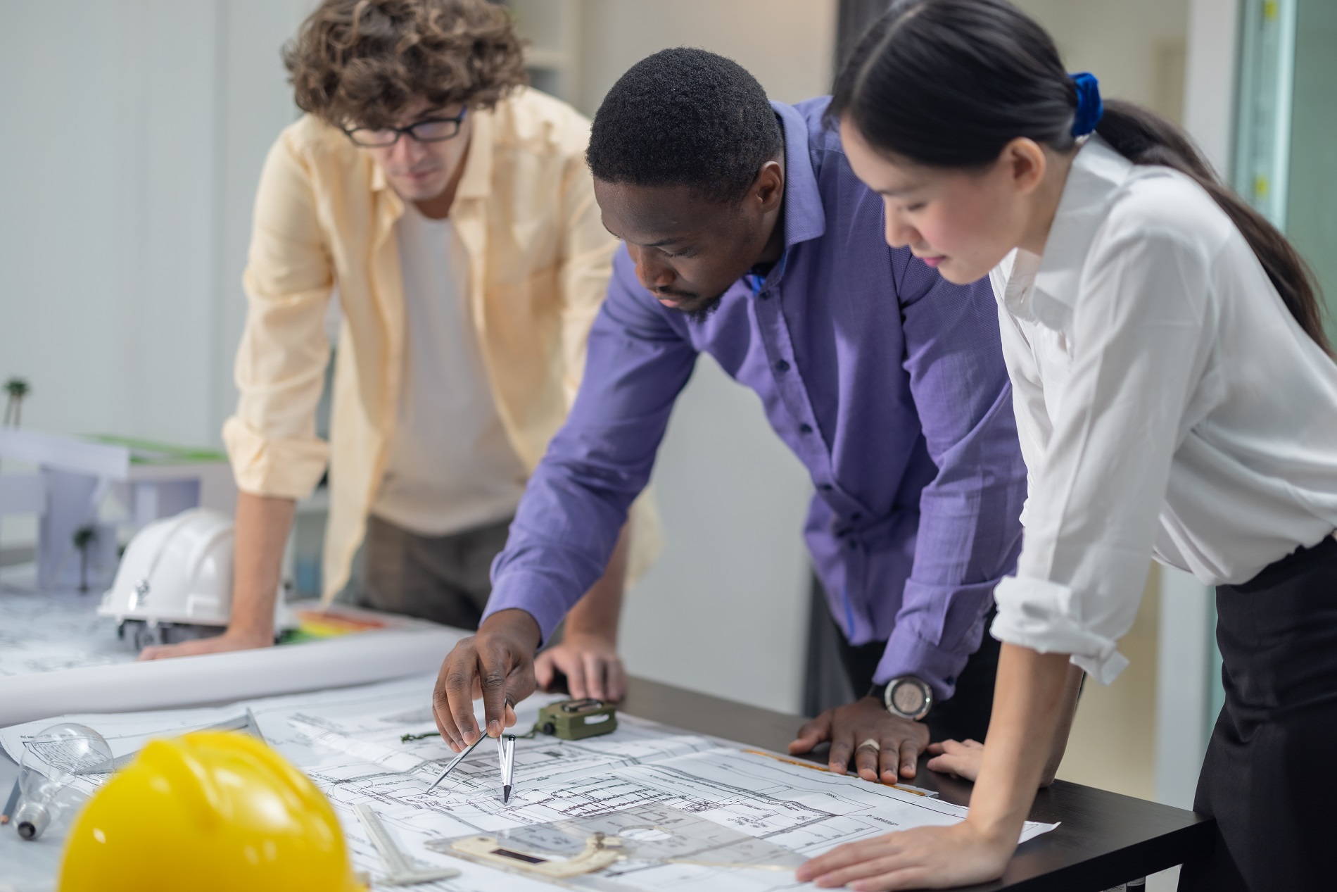 Architects plan low-carbon construction, analyzing blueprint, la Multicultural team of architects collaborates on a low-carbon building project, analyzing blueprints, drafting layouts, calculating precise structures and materials for eco-friendly construction.