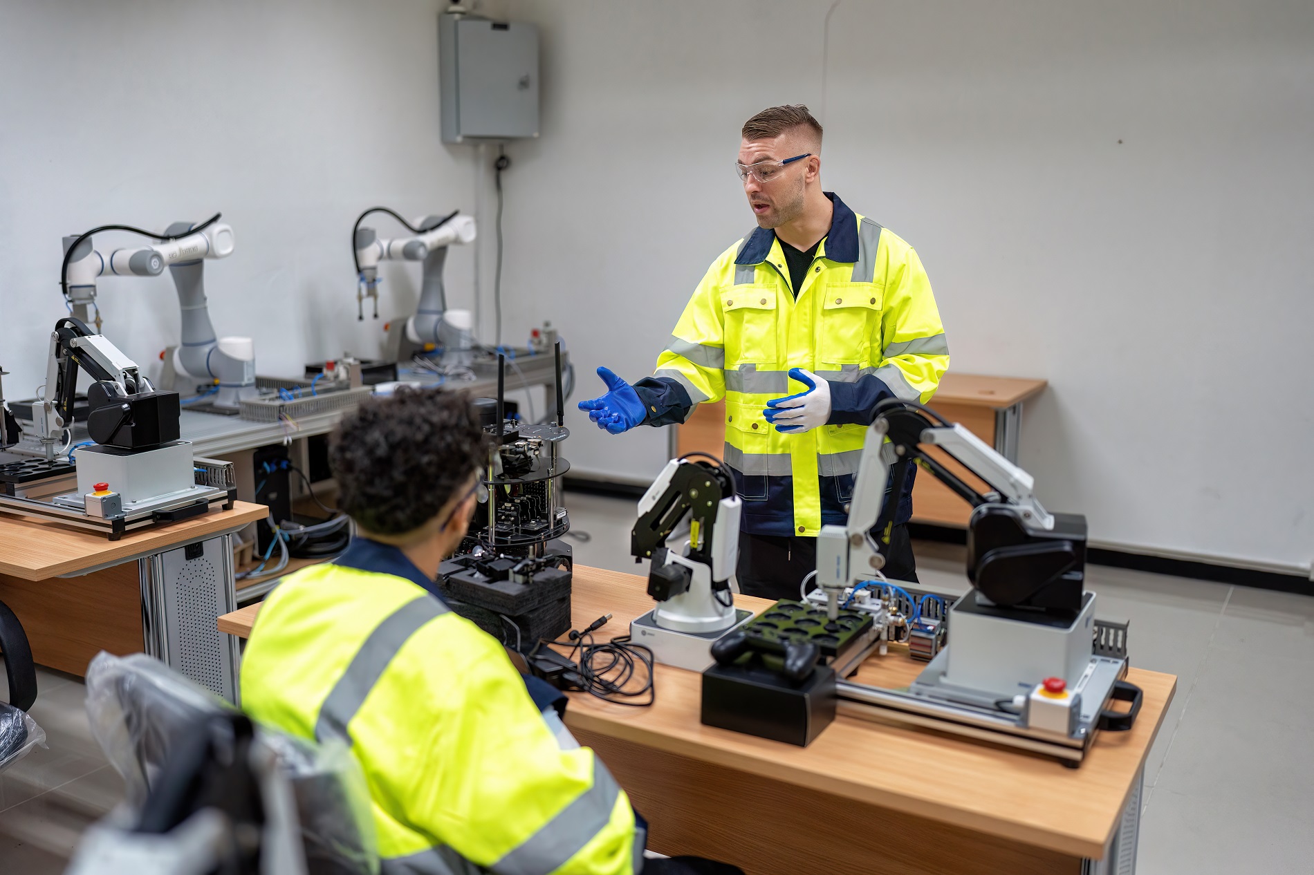 Engineer teach trainee how to operation maintenance and programing robot arm in training room Engineer teach trainee how to operation maintenance and programing robot arm in training room